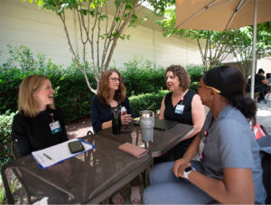 A group from WakeMed Health and Hospitals sits at a table outside.